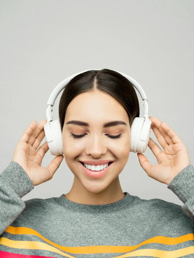 Woman in Gray Sweater Wearing White Headphones